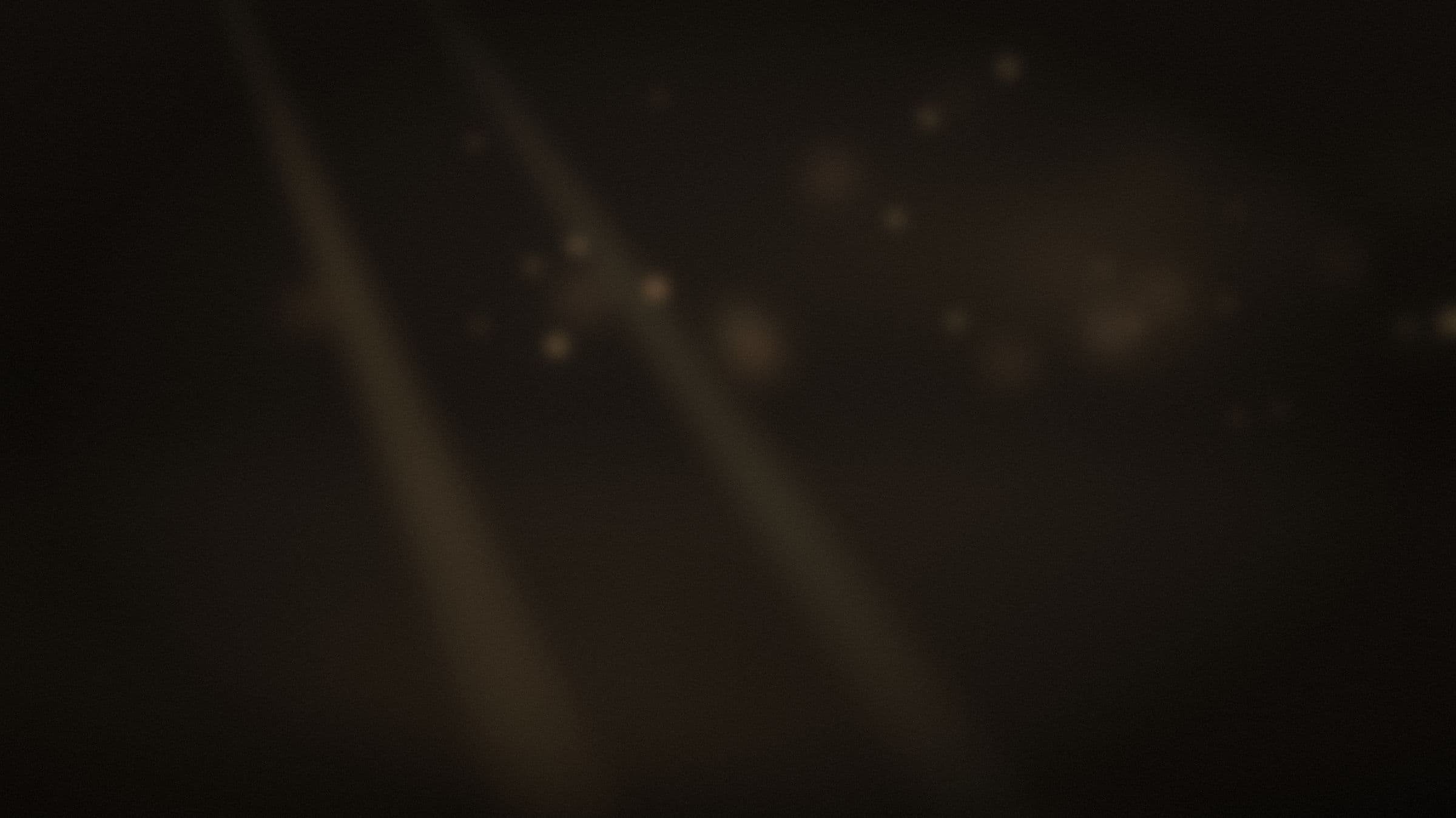light beams and warm bokeh drifting through a dark candlelit room