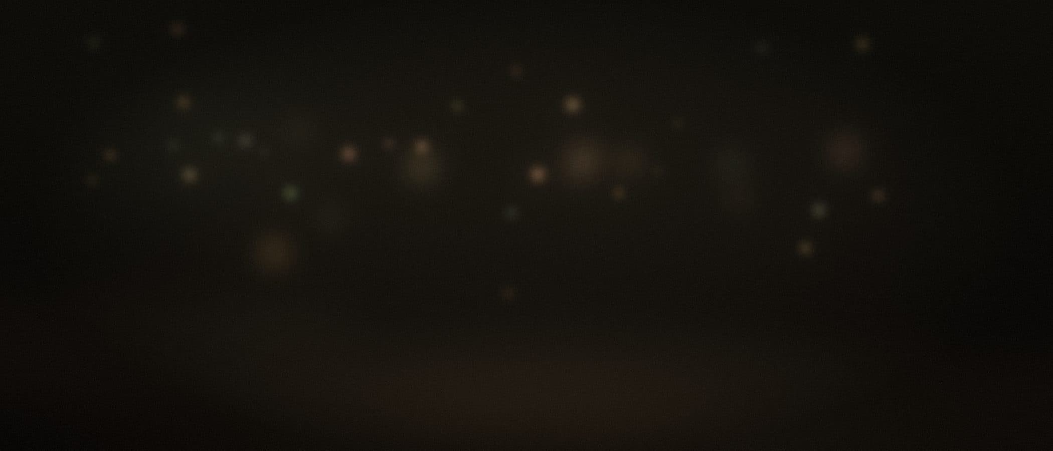 warm and olive-tinted string-light bokeh scattered through a garden at night